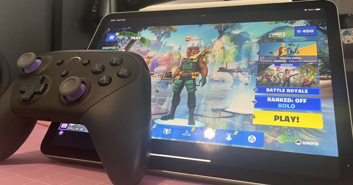 An Amazon Luna controller sits next to a tablet that's running Fortnite on Luna cloud services
