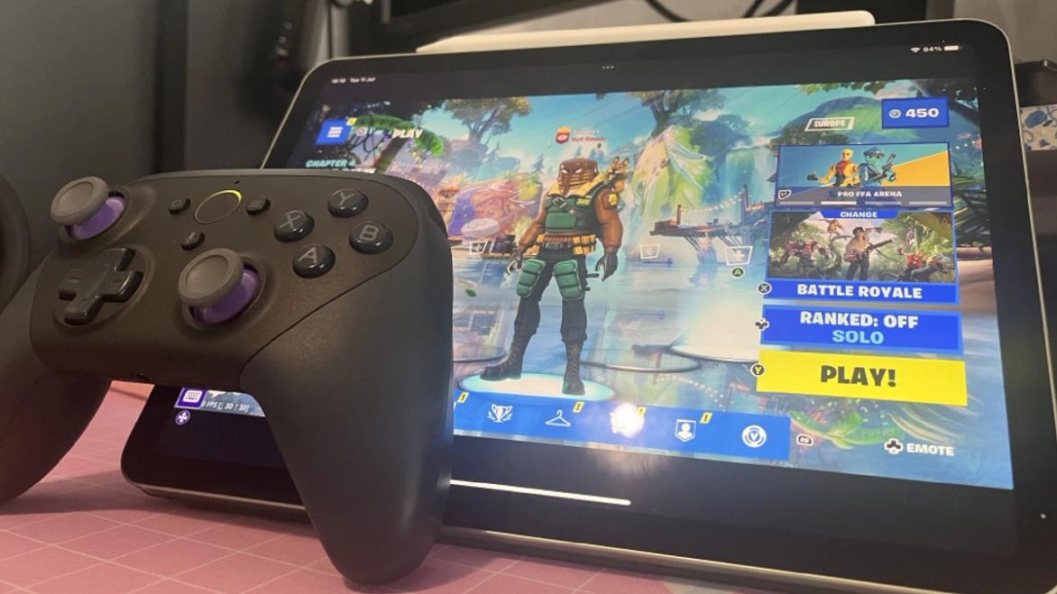 An Amazon Luna controller sits next to a tablet that's running Fortnite on Luna cloud services