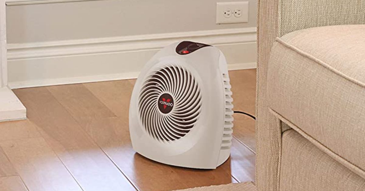 A white, compact heater sat on a wooden floor.