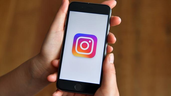 How to tell if someone restricted you on Instagram holding phone