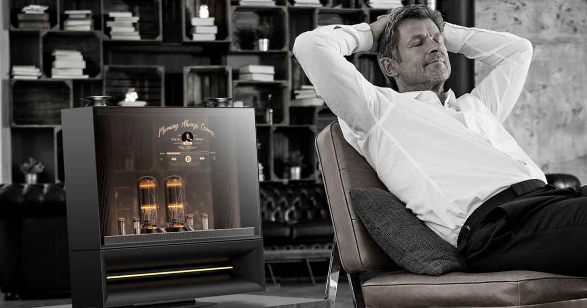 A monochrome image of a man relaxing next to the LG DukeBox