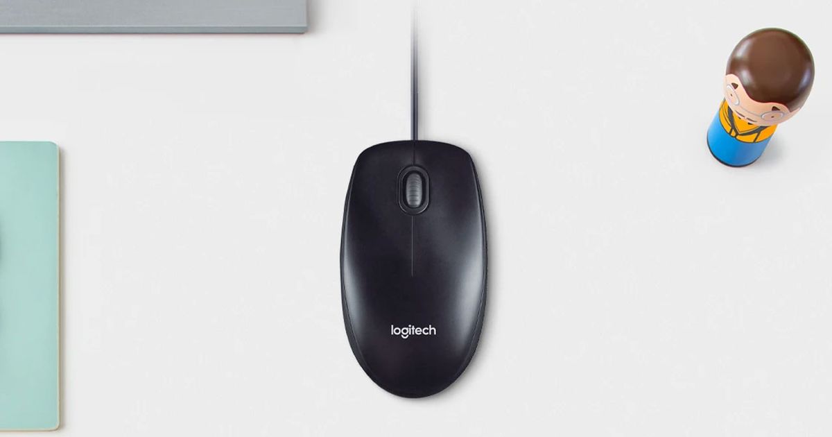 Image of a black wired mouse on a white desk next to a figure of someone with brown hair.