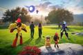 Pokemon Go players standing next to Pokemon in grassy area