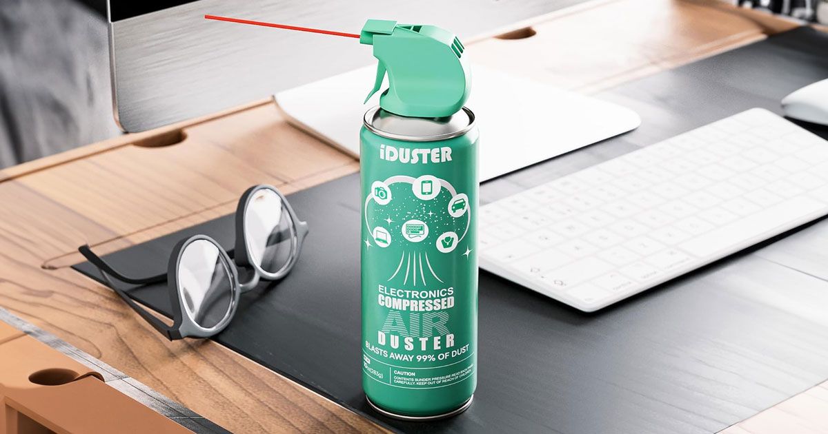 A turquoise compressed air spray can sat on a desk next to a white keyboard and a pair of black glasses.