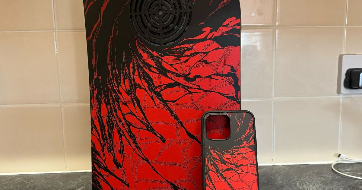 Dbrand Carnage darkplates for PS5 behind a Carnage iPhone 15 Pro Max Grip case