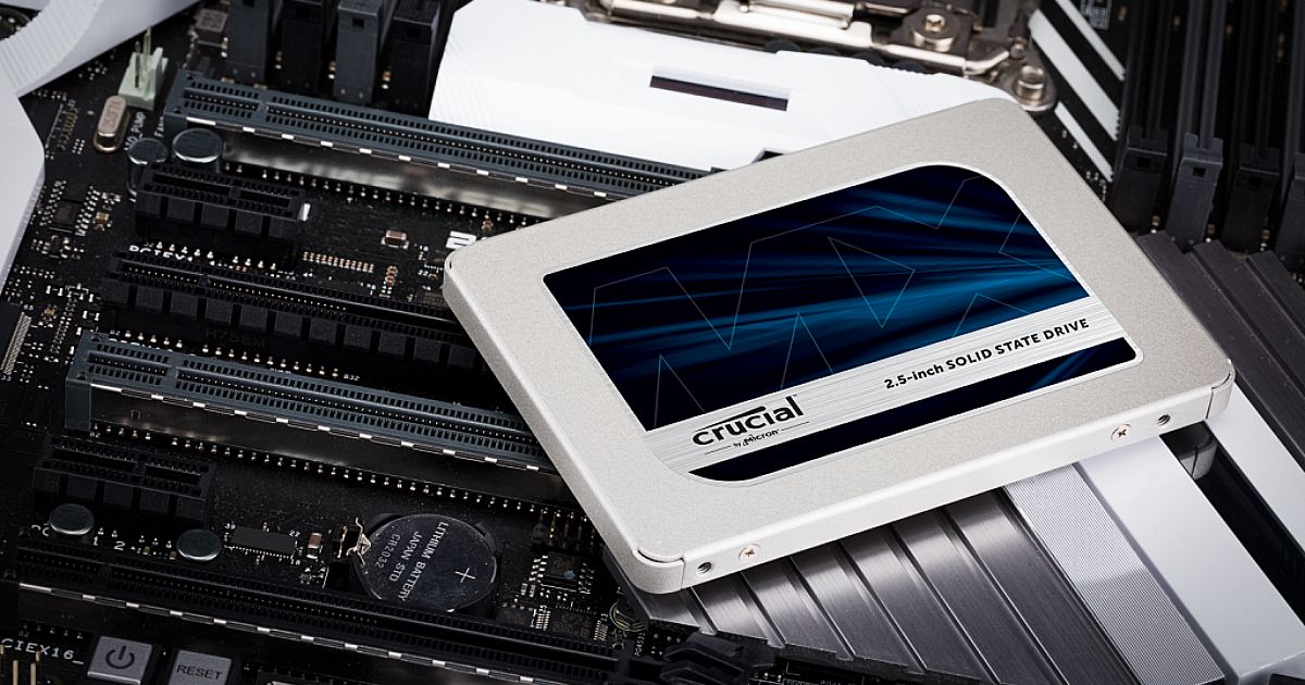 A white 2.5-inch SSD with a blue label on top, the SSD itself on top of internal PC components.