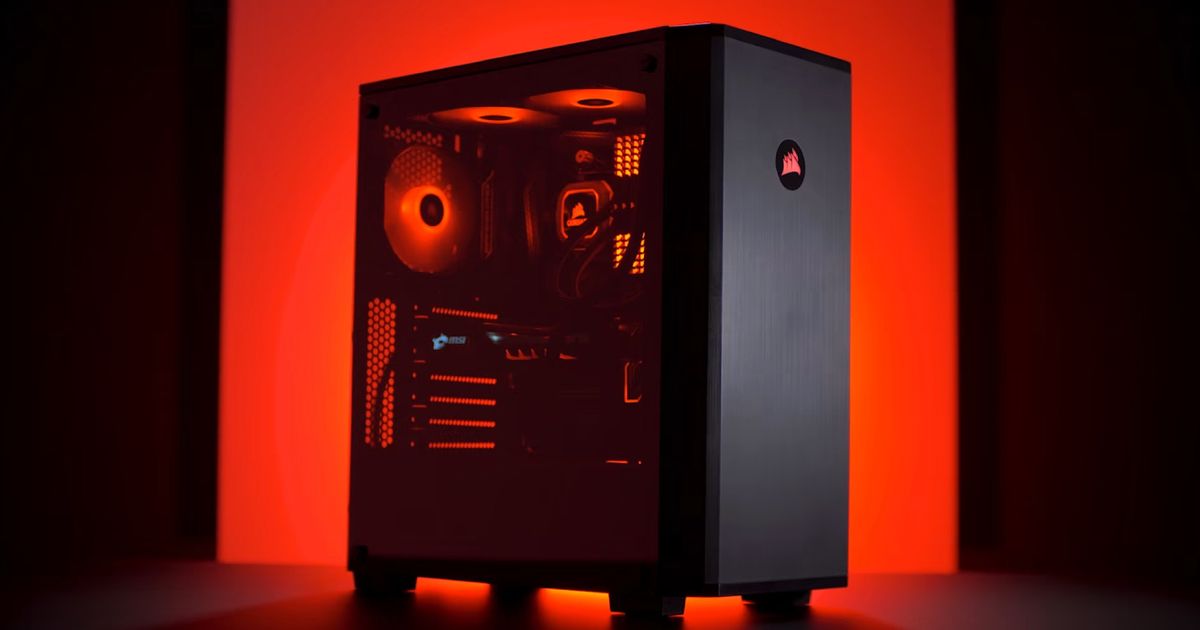 A black PC case with a clear side in a red-lit and black room.