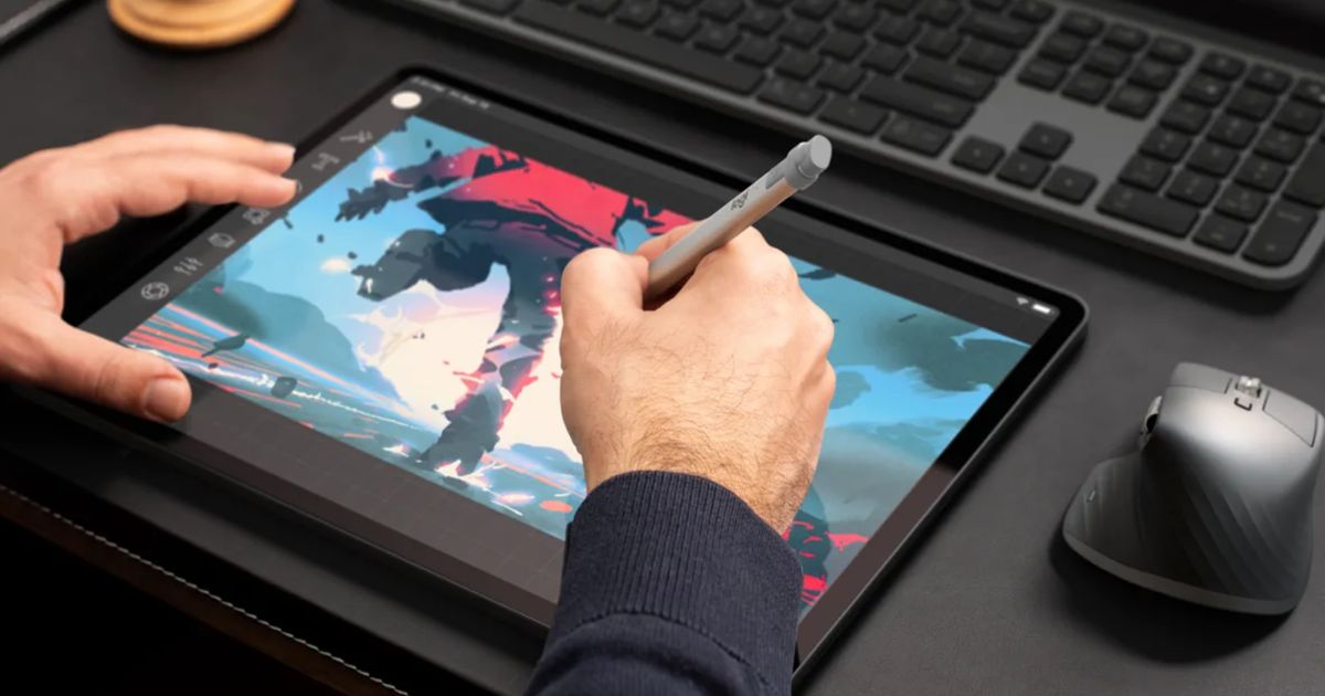 Someone using a silver stylus to draw on a black tablet.