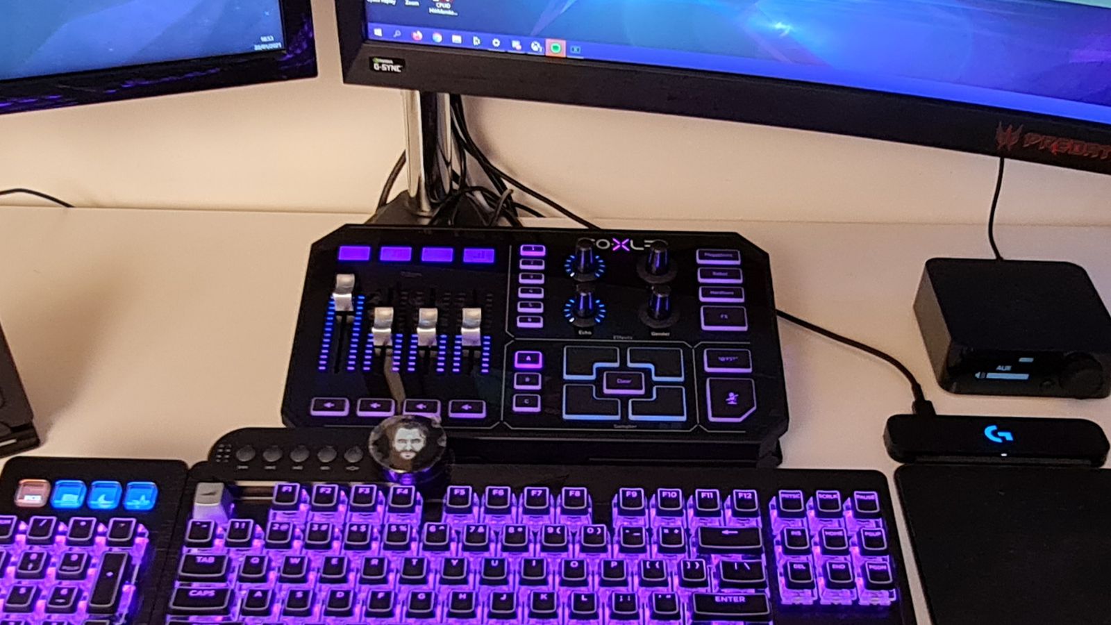 A GoXLR with purple and blue lighting sits above an RGB keyboard