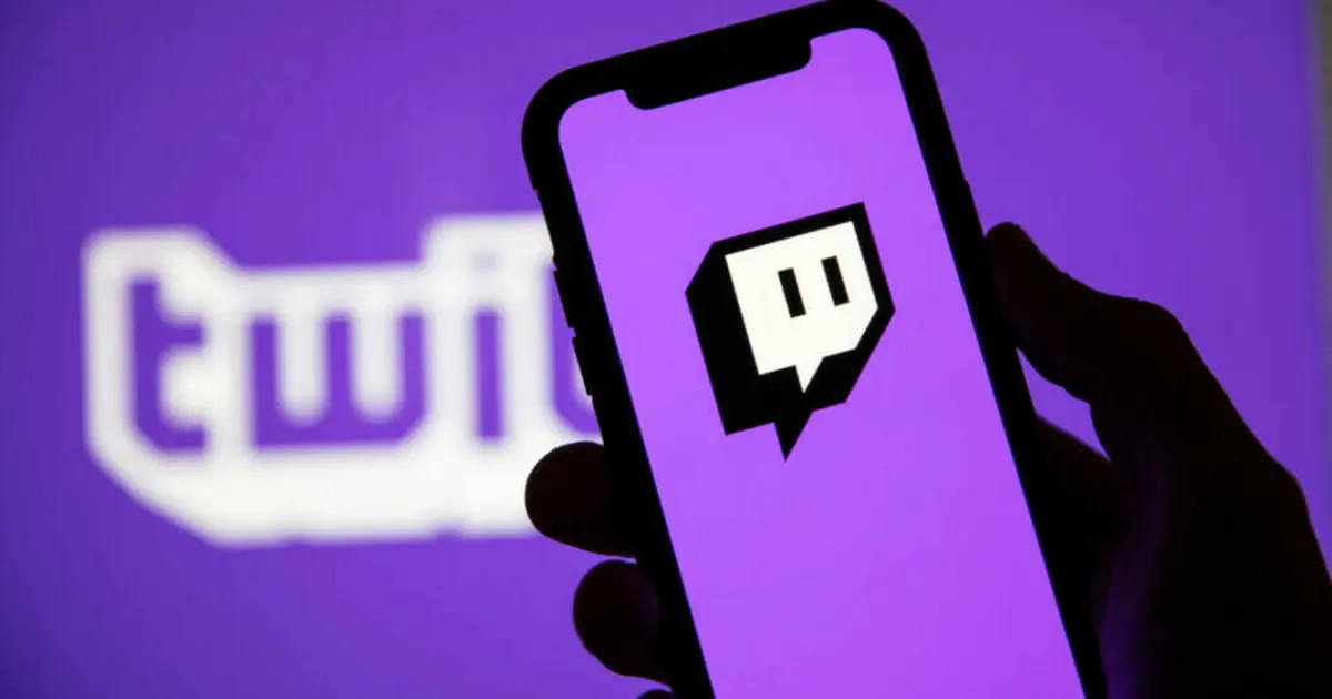Twitch drops - A hand holds a phone showing the Twitch logo