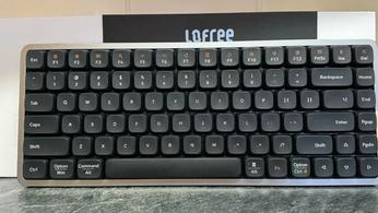 Lofree Flow keyboard in black in front of the box and on a marble countertop