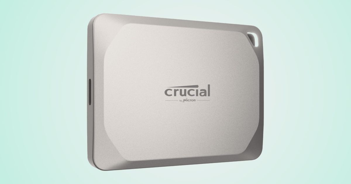 A silvery-grey portable SSD with grey branding on the front, with the SSD in front of a mint green and white gradient background.