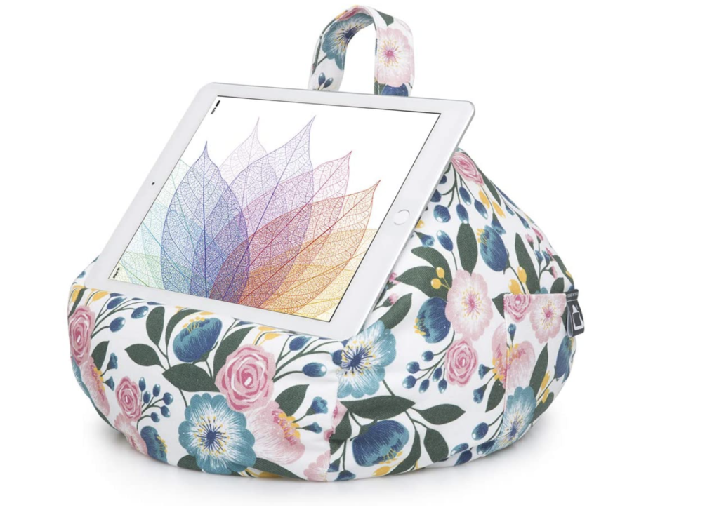 A white bean bag with a floral print, a tablet laying on top of it.