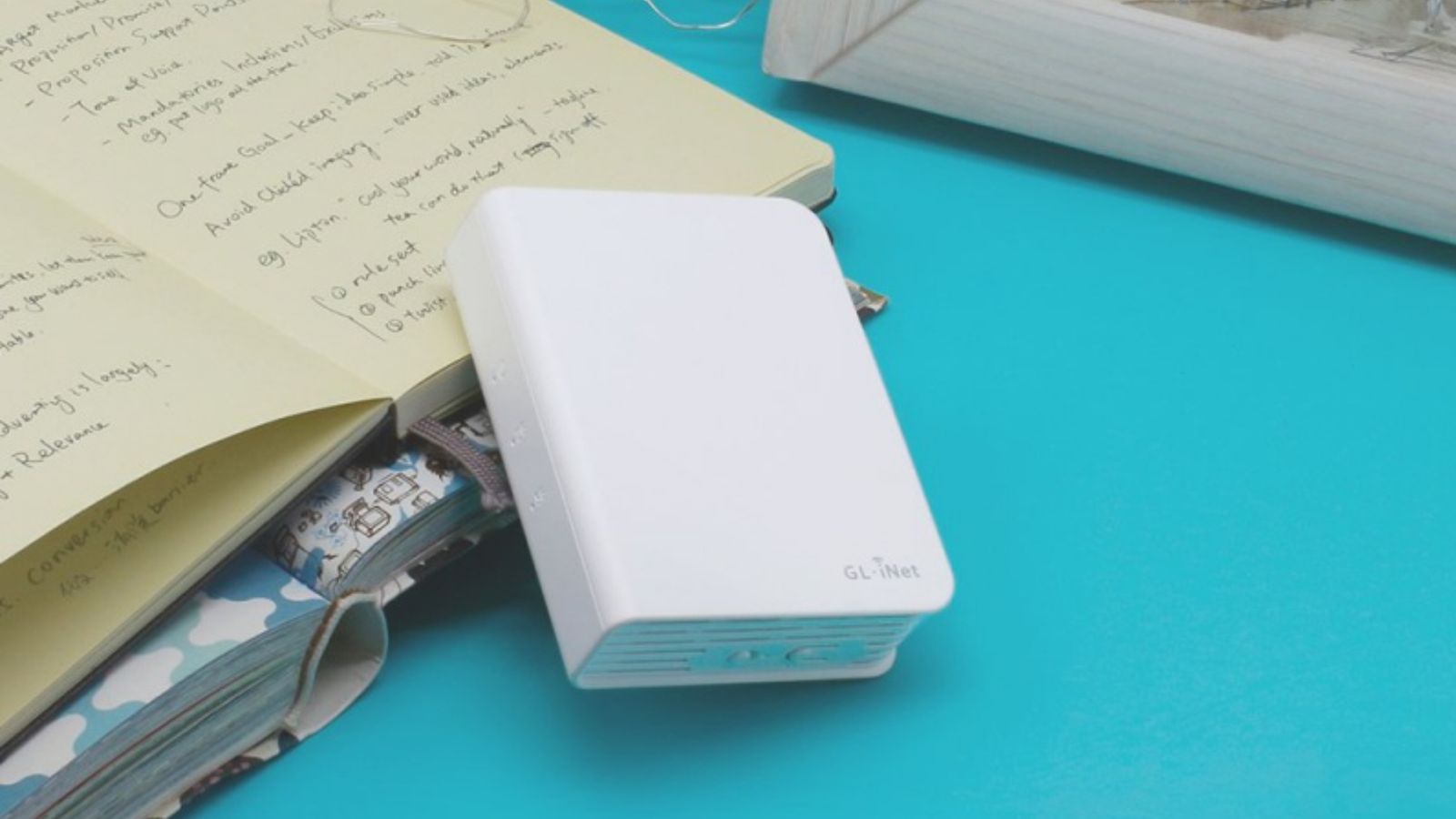 A small white Wi-Fi router resting against a book.