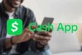 Can you deposit a check on Cash App? - An image of the Cash App logo with a person using their smartphone in the background