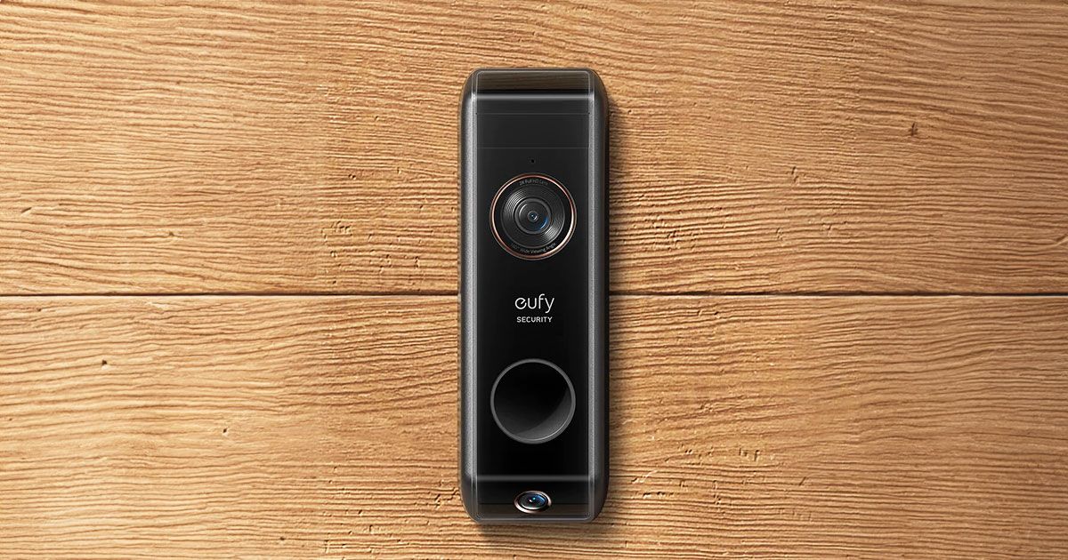A black video doorbell mounted to a brown wooden wall.