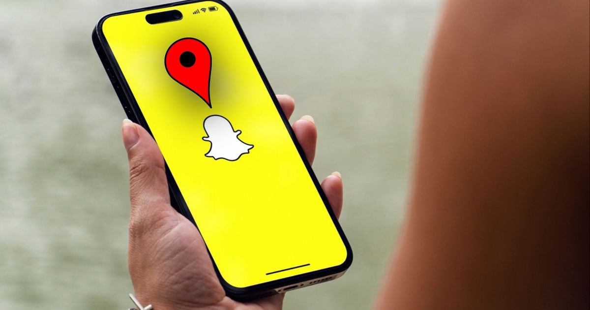 Person holding a phone with the Snapchat app on the screen. A location pin is above the iconic Snapchat ghost logo.