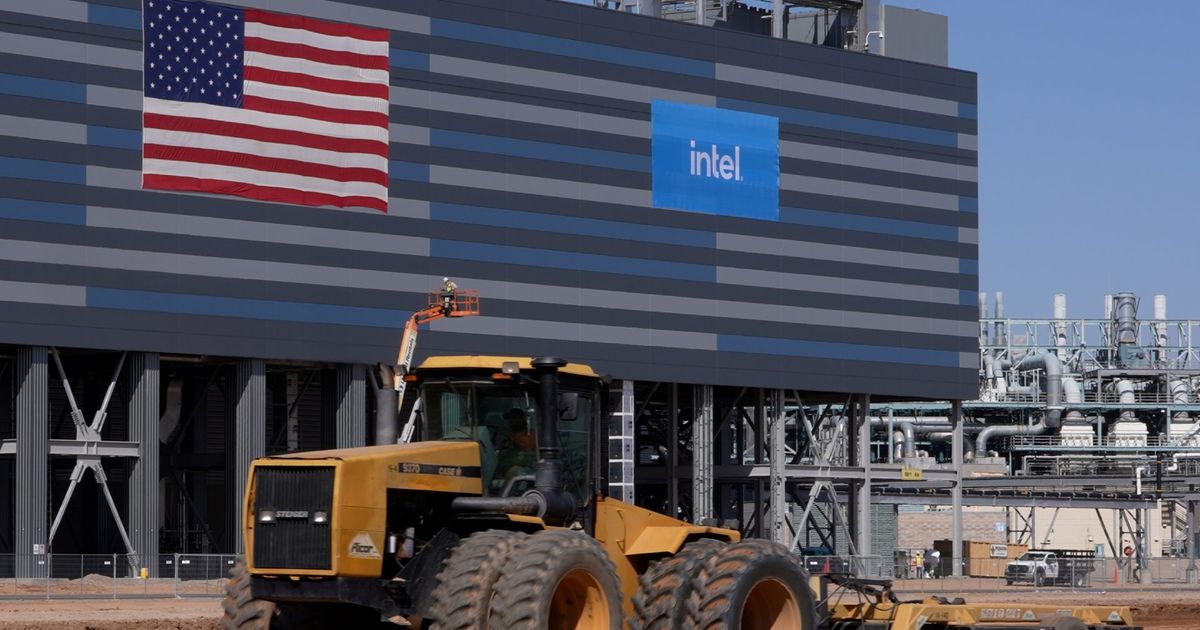 intel logo and US flag at construction site with yellow machine