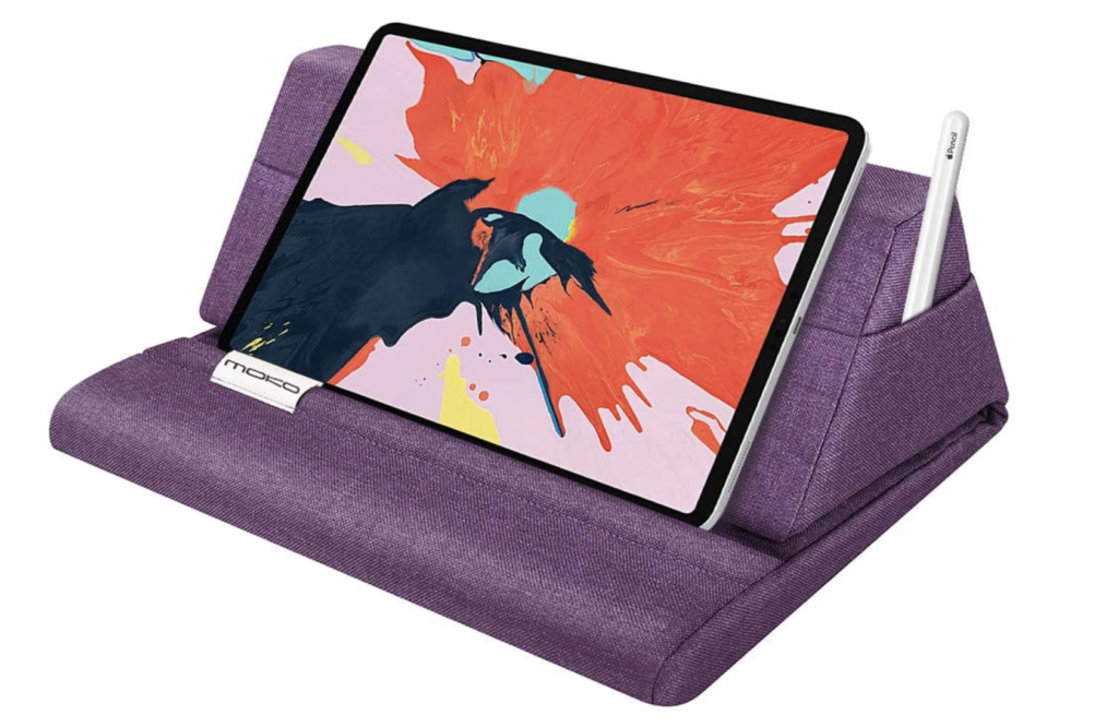 A purple pillow stand with a tablet resting on it and a slot for a stylus.