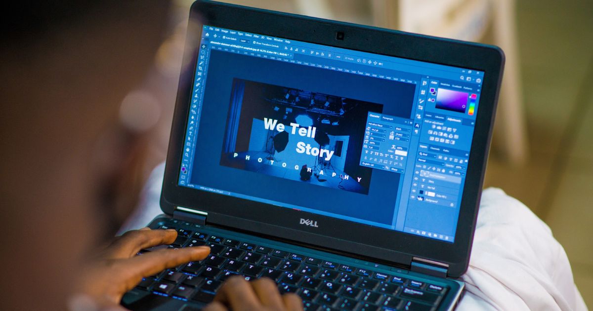 Someone editing a piece on work on Photoshop on a black Dell laptop.