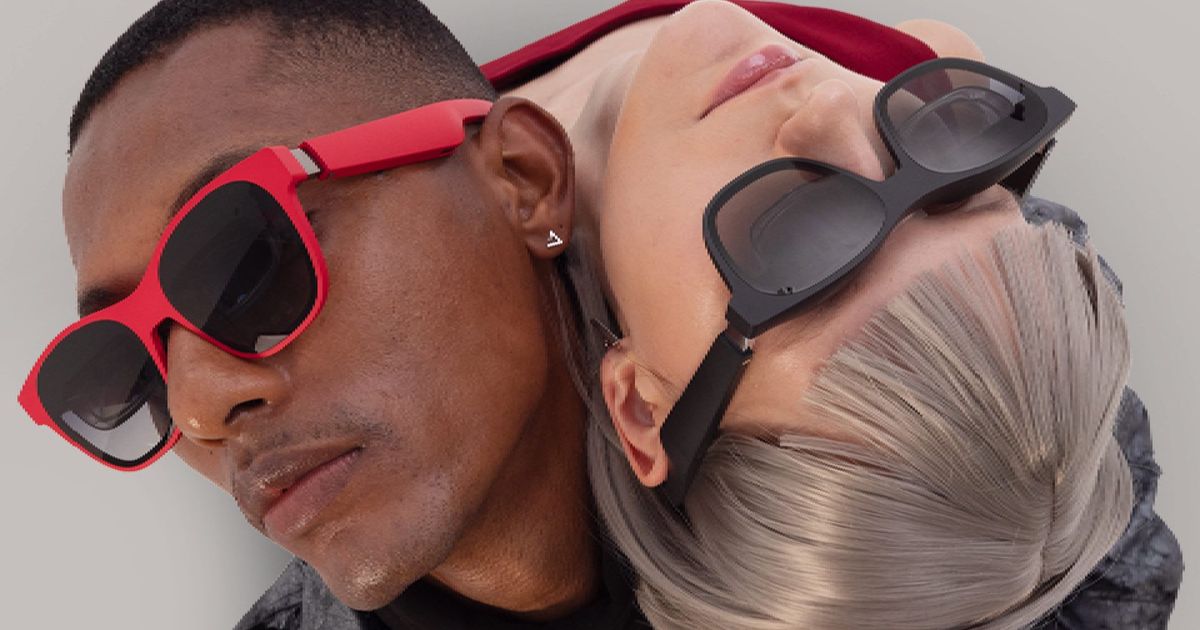 An intertwined man and woman wearing a pair of XReal Air 2 augmented reality smart glasses