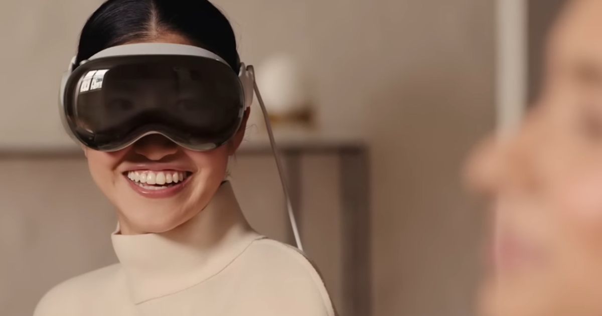 A woman wearing the Apple Vision Pro with a big smile