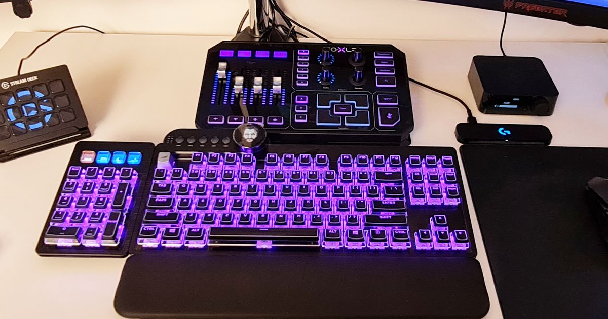 A GoXLR audio mixer sits above a gaming keyboard with the same purple and blue lighting theme