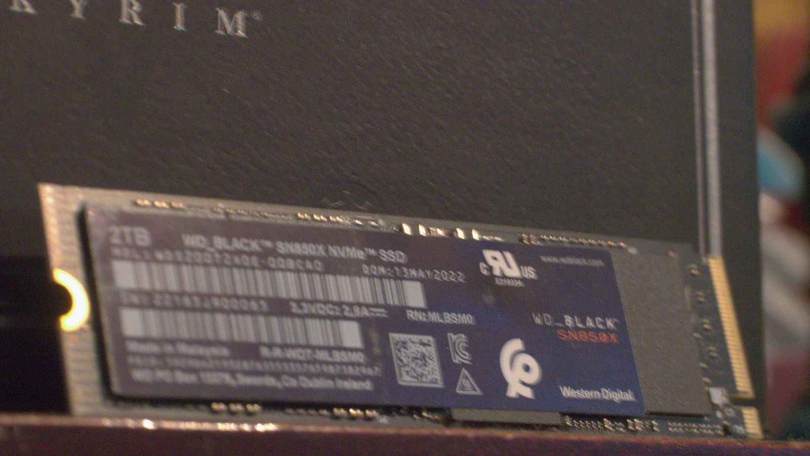 A WD Black SN850X SSD resting against a Skyrim box.
