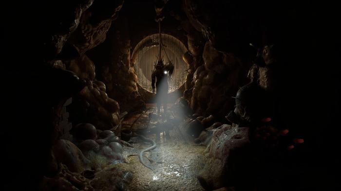 A figure shines a torch in a dark tunnel