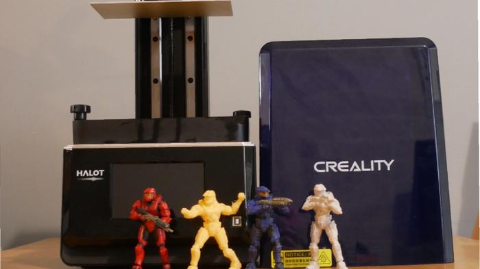 An image of a Creality Halot One Plus review alongside figurines of Red vs Blue Spartans 
