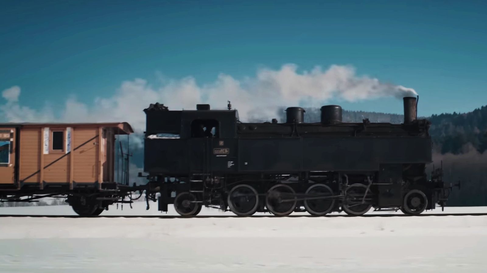 Last Train Home - side of a black steam train travelling through snow
