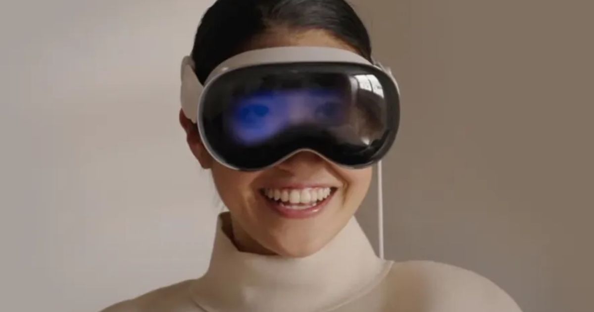 A woman gleefully smiling with the Apple Vision Pro on her face