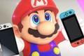 Mario looking up and holding Nintendo Switch 2 consoles 