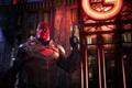 Red Hood with an orange light shining on the wall behind him - Gotham Knights local co-op