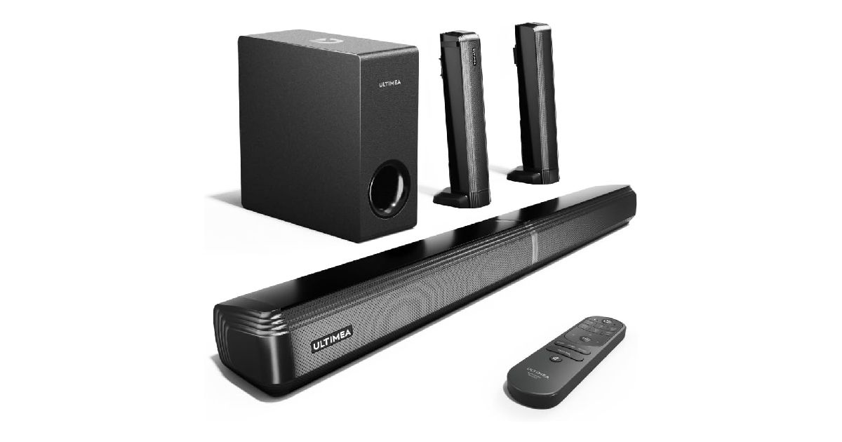 A long black soundbar with a remote in front of it as well as two speakers and a subwoofer behind it.