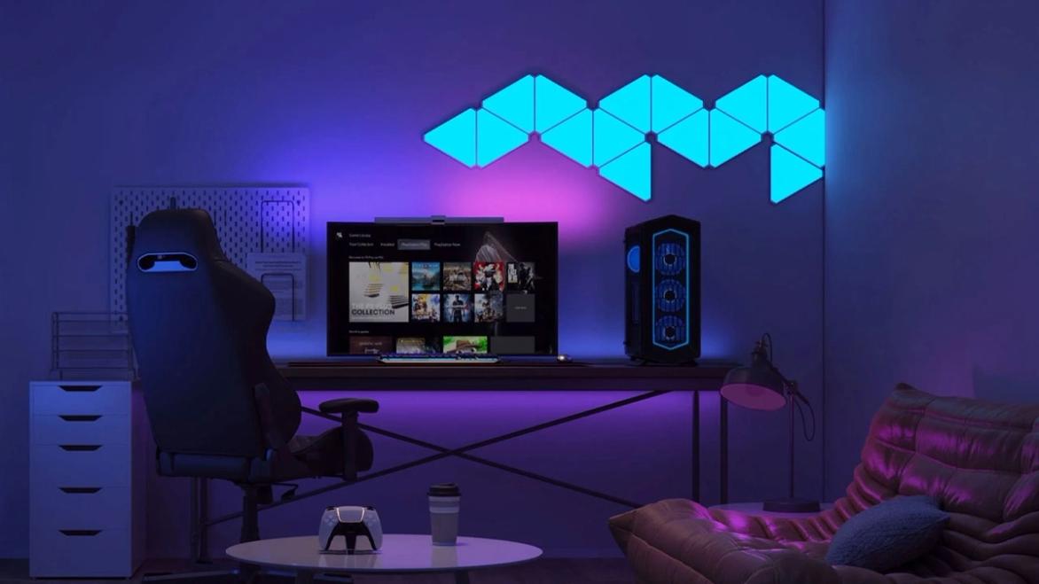 A set of blue panel lights mounted to a wall above a gaming setup.
