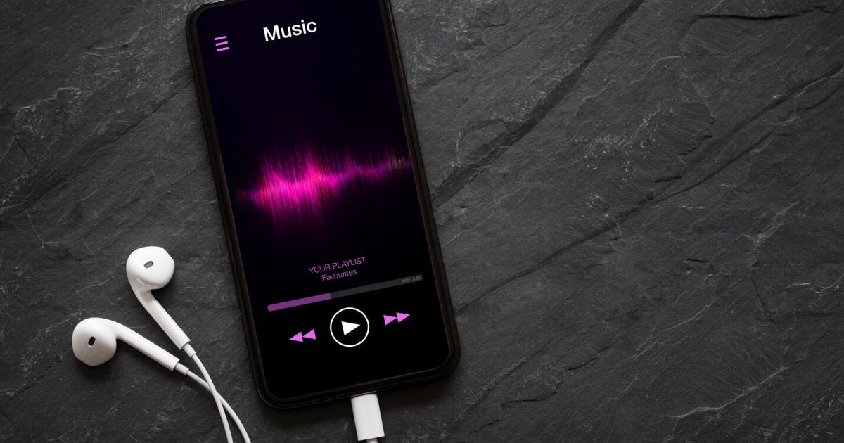 Apple Music vs Spotify - phone with headphones