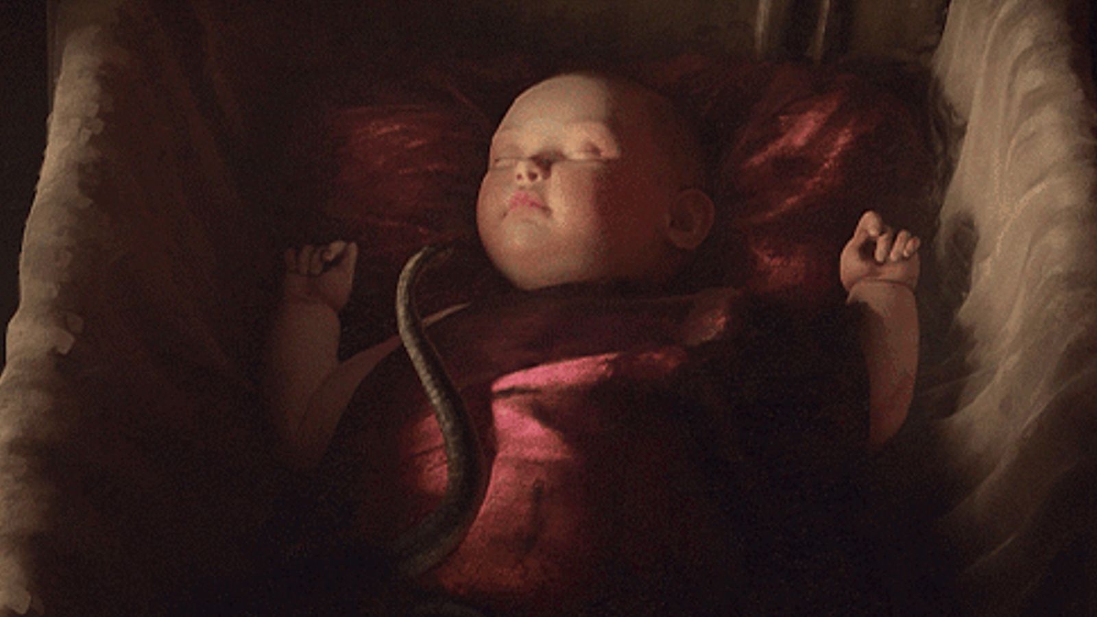 Crusader Kings 3: baby lies in red cradle as a snake slides across it.