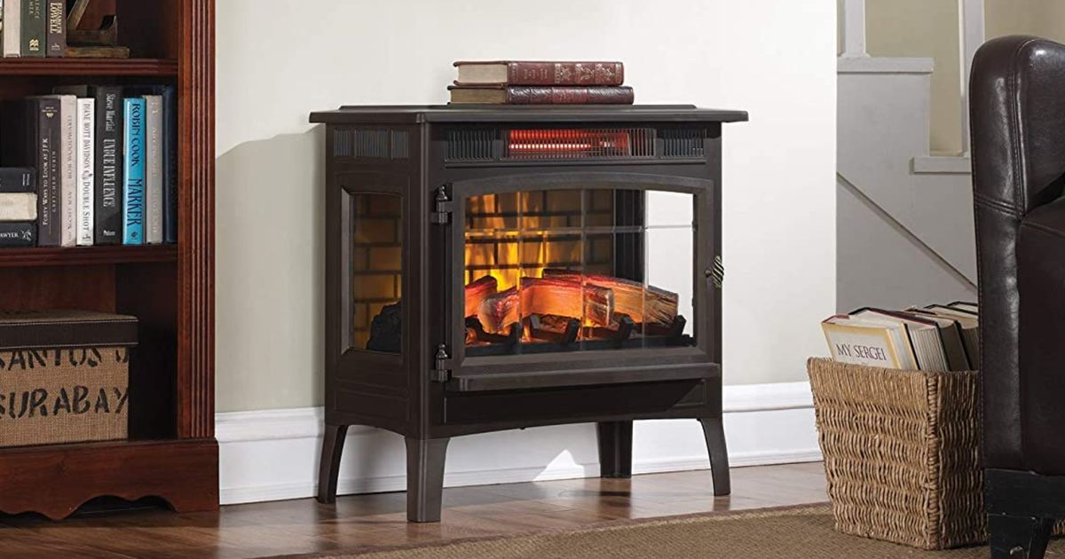 A brown fake fireplace eletric infrared heater with books resting on top.