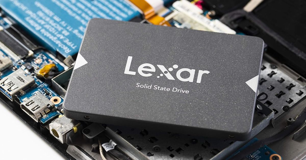A dark grey SSD with lighter grey Lexar branding on the front on top of internal PC components.