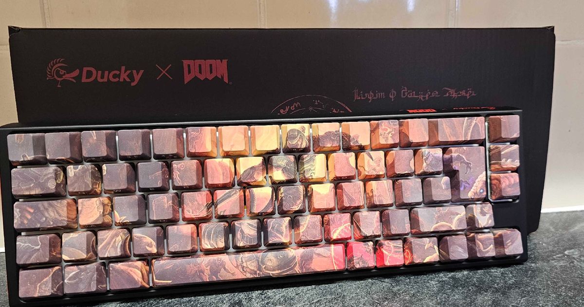 Ducky x DOOM One 3 SF keyboard lying at an angle against the box