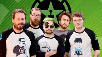 The achievement hunter group standing together on a background of their logo