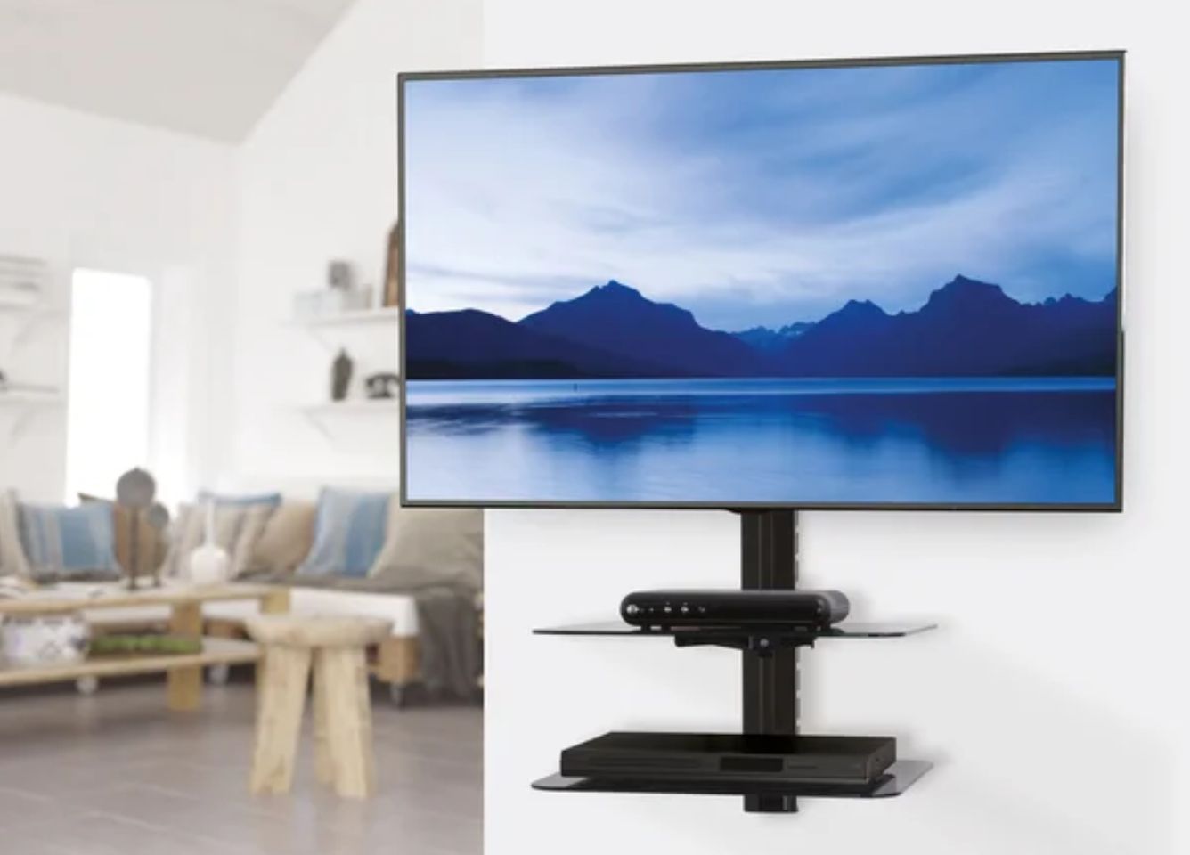 Image of a black TV wall mount stand and shelf with a TV secured to it featuring a lake and mountains on its display.