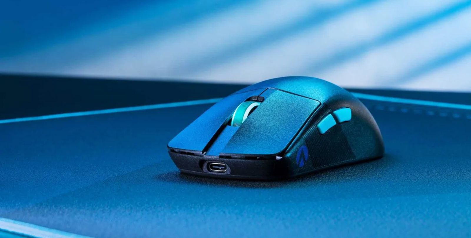 Image of a black, wireless ASUS mouse on a mousepad in a blue lit room.
