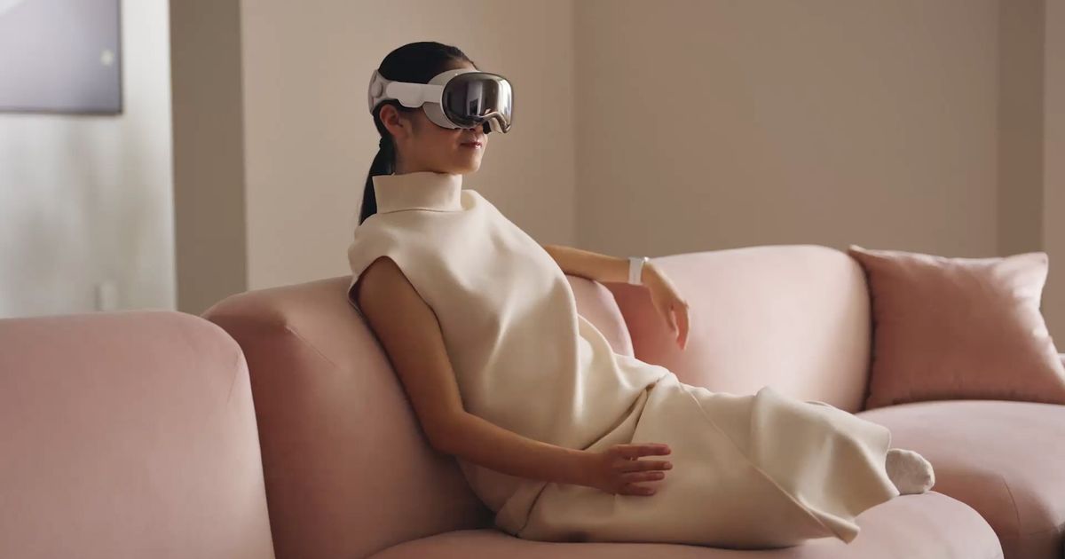 Woman using an Apple Vision Pro while sitting down on the sofa