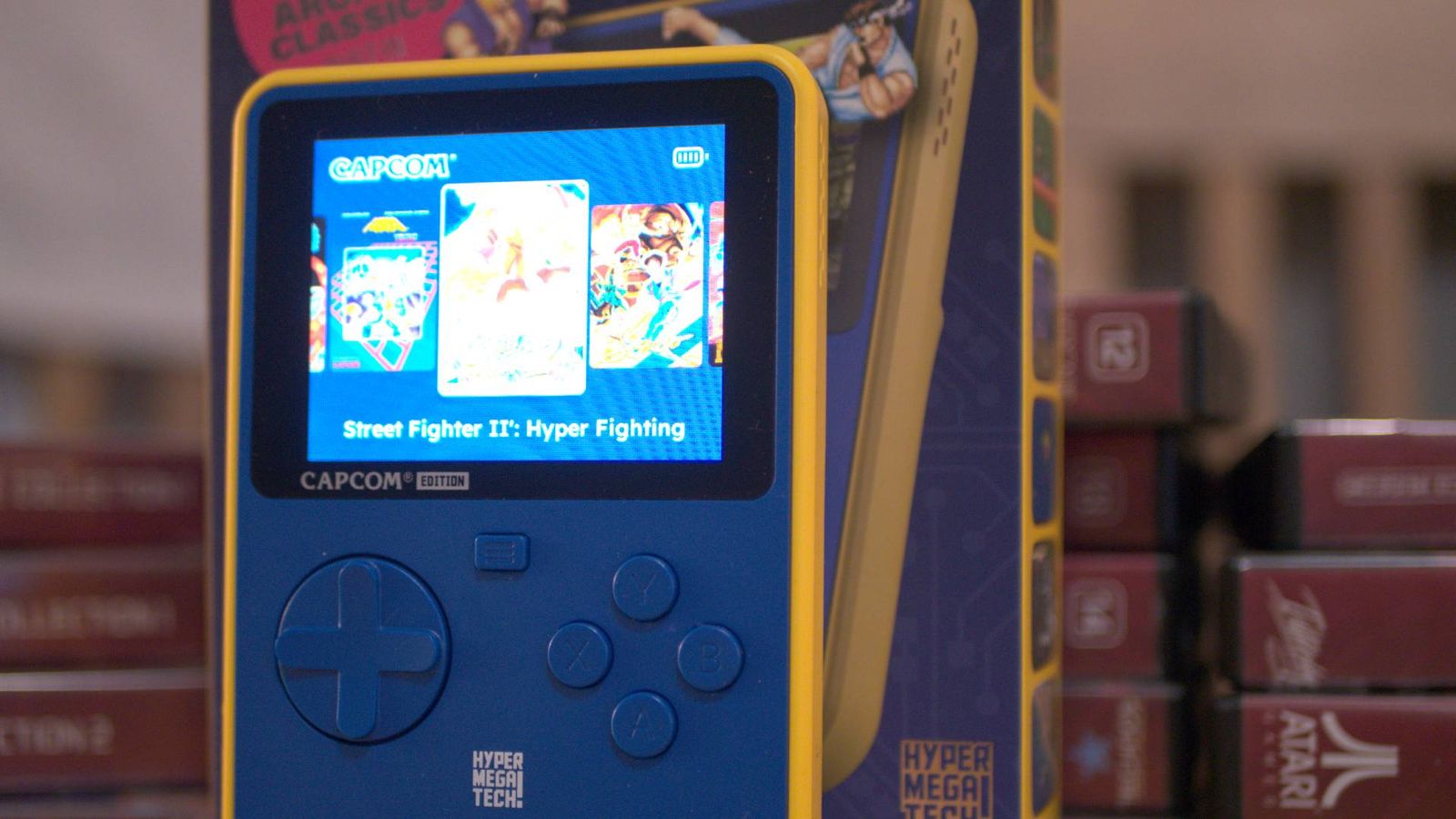 A HyperMegaTech Super Pocket Capcom Edition against a stack of evercade cases
