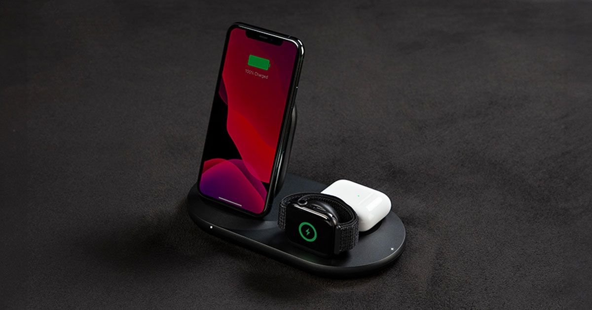 A smartphone, black smartwatch, and a white Airpod case charging on a black charging pad.