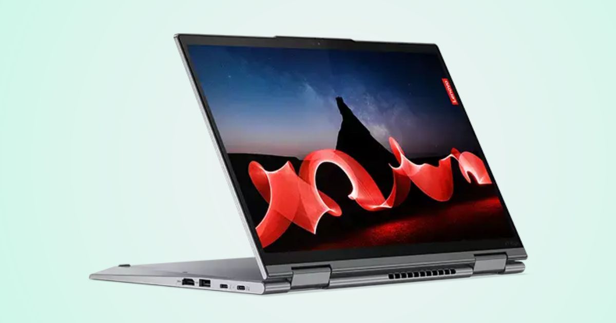 A silver laptop with a red pattern in front of a night sky on the display.